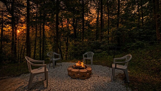 A fire pit with three chairs arranged around it in a forest setting. - Peaceful 3BR*Firepit*Games*8 Mins to National Park (Cosby)