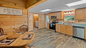 A wooden interior with a kitchen area featuring a microwave, oven, and sink. - Peaceful 3BR*Firepit*Games*8 Mins to National Park (Cosby)