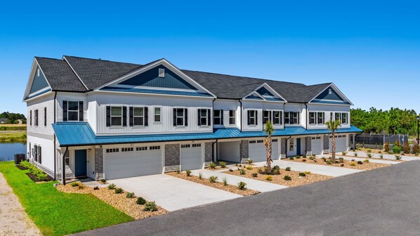 A modern two-story residential building with a blue roof and white siding.