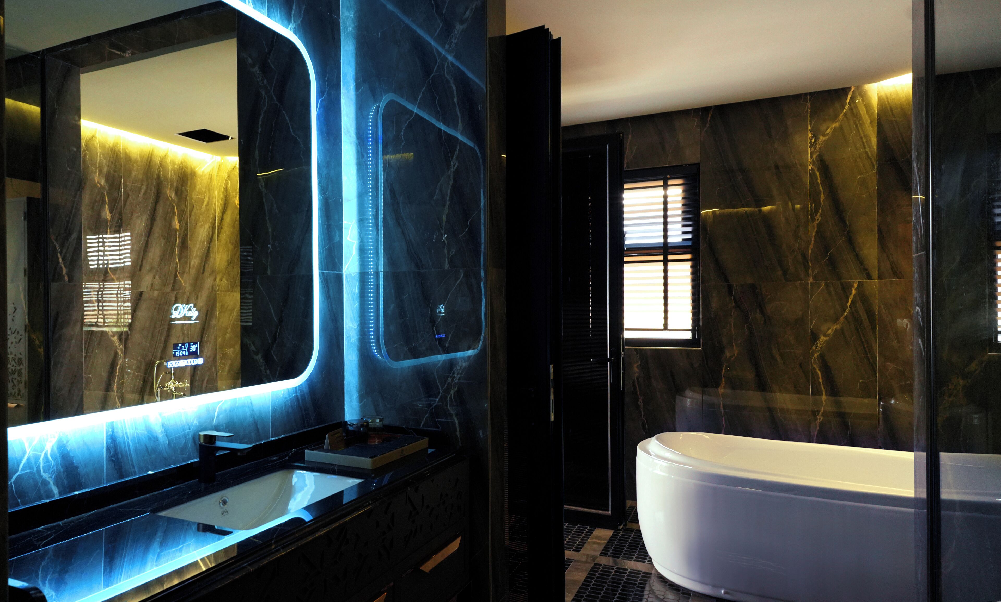 A modern bathroom with a large mirror, a sink, and a bathtub.