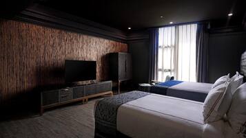 Una habitación de hotel moderna con una cama grande, un televisor de pantalla plana, un armario y una ventana con cortinas.