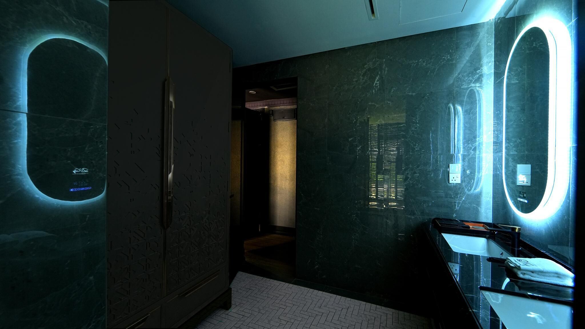 A modern bathroom with a large mirror, a vanity, and a shower area.