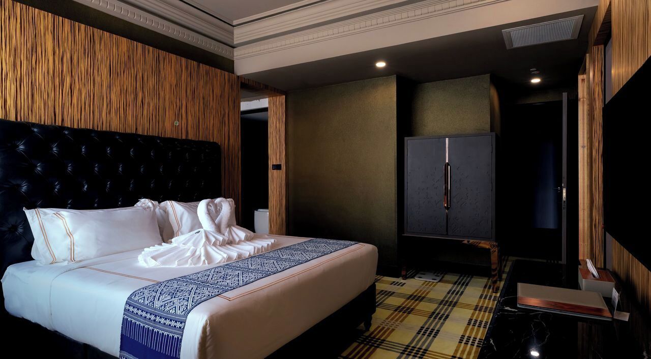 A hotel room with a large bed, a wardrobe, and a television.