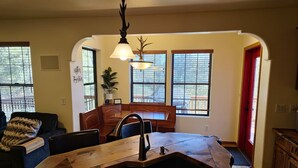 A kitchen with a central island, a dining area with a sofa, and a red door. - Upscale Family Mountain Cabin ~Deck w/ views + Fire Table ~Game Room (Flagstaff)