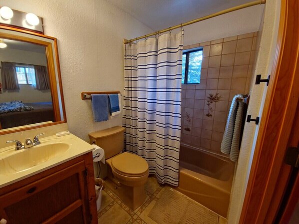 Un baño con lavamanos, inodoro y bañera.