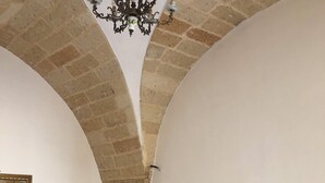 Una stanza con un divano bianco, un armadio di legno e un lampadario.