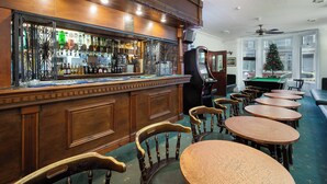 A bar area with wooden furniture, a pool table, and a Christmas tree. - Royal Oakwell Hotel (Blackpool)