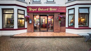 The exterior of the Royal Oakwell Hotel with a brick facade, large windows, and a visible Christmas tree inside. - Royal Oakwell Hotel (Blackpool)