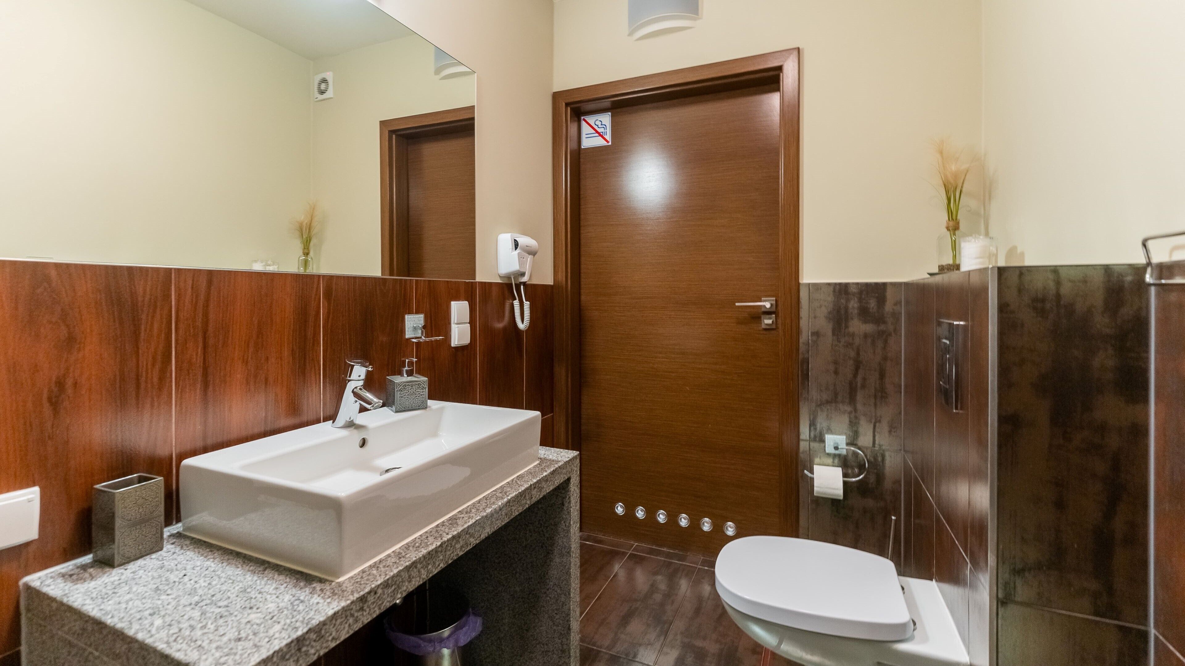 Een moderne badkamer met een groot wastafel, toilet en douchehoek.