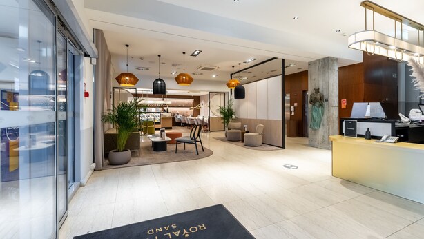A modern hotel lobby with a reception desk, seating area, and a bar. - Apartamenty Sun & Snow Royal Tulip (Kolobrzeg)