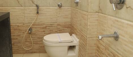 A bathroom with a toilet, a shower, and a sink.