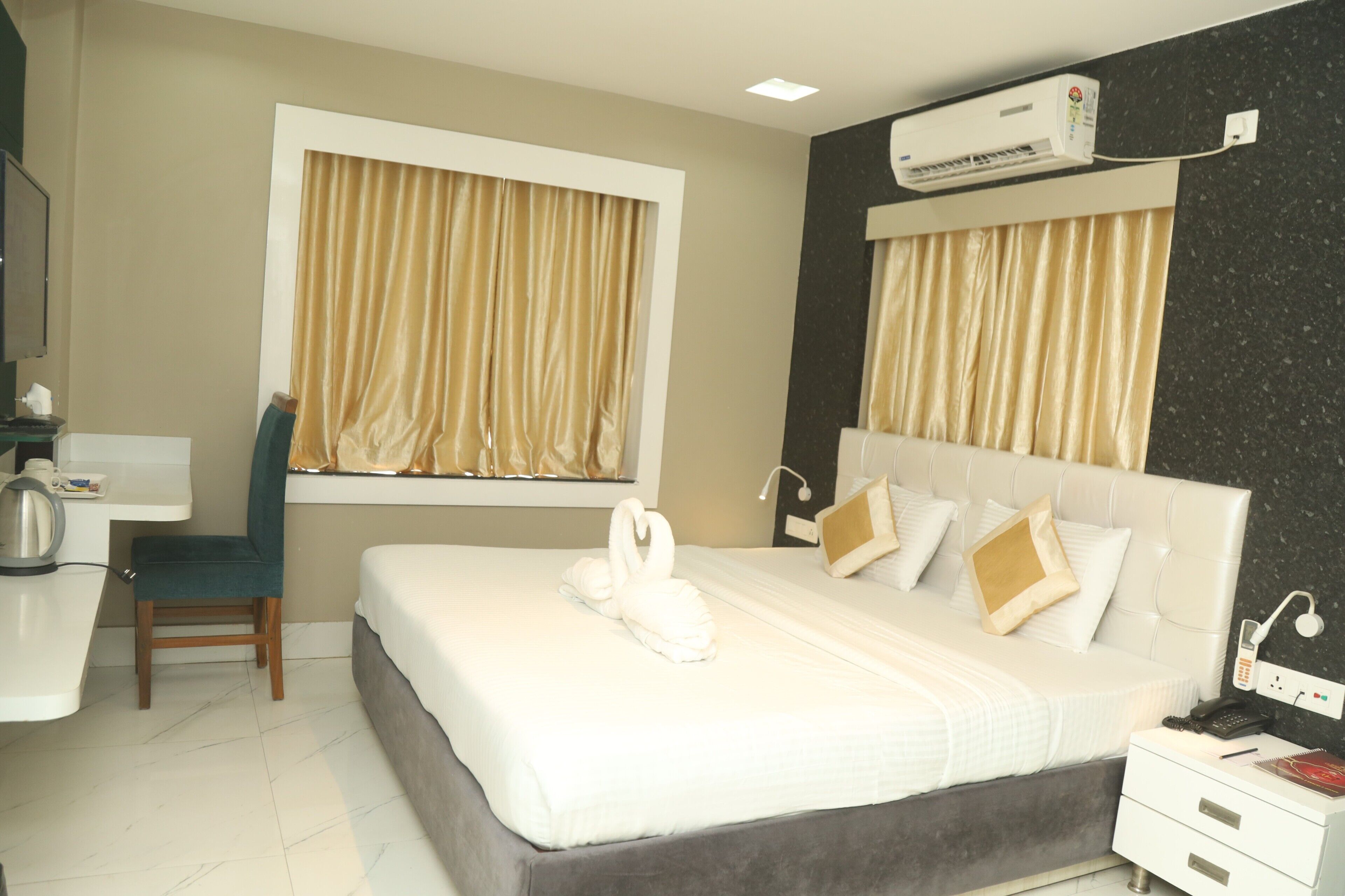 Een hotelkamer met een bed, een bureau, een stoel en een airconditioning.