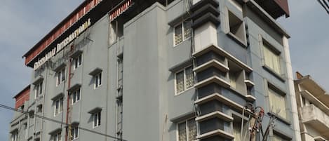 A multi-story building with balconies and a sign indicating it is a hotel.