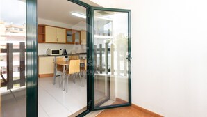 Een moderne keuken met een eethoek, zichtbaar door een glazen deur.