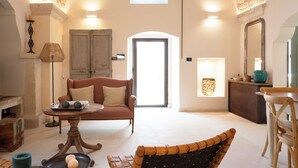 Un salon spacieux avec un plafond haut, un canapé, une table à manger et une chaise.