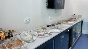 A buffet setup with various food items and utensils. - Qorasuv hotel (Tashkent)