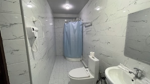 A bathroom with a toilet, sink, and shower curtain. - Qorasuv hotel (Tashkent)