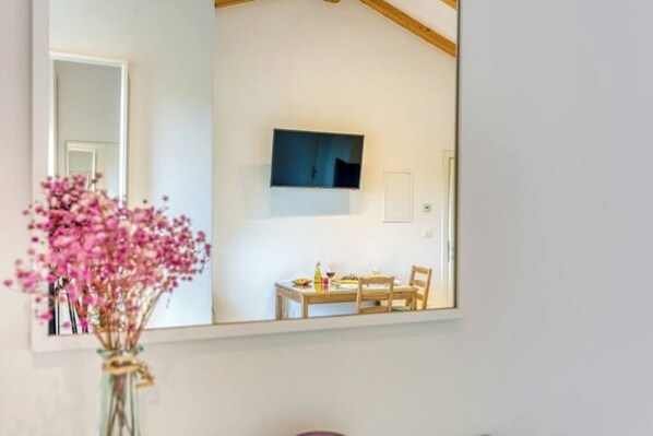 Une chambre avec un lit, une table de chevet, un miroir et une fenêtre.