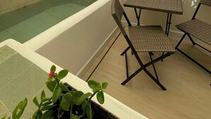 An outdoor pool area with a seating arrangement and a decorative wall.