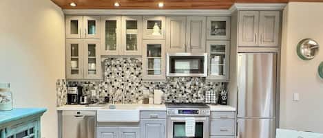 Kitchen features stainless steel appliances, a central island, and a small window above the microwave.