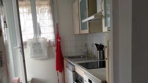 A compact kitchen with a washing machine, a sink, and cabinets. - Charming T3 villa near the sea (Le Pradet)
