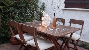 Une table en bois, des chaises, une bouteille de vin et un chandelier.