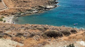 Un paisaje costero con terreno rocoso y un mar azul y despejado.