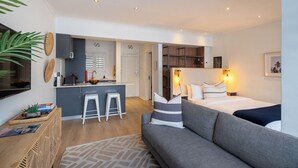 Un apartamento moderno con cocina, comedor, sala de estar con sofá y cama.