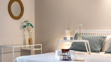 A neatly arranged hotel room with a bed, bedside table, and a small desk.