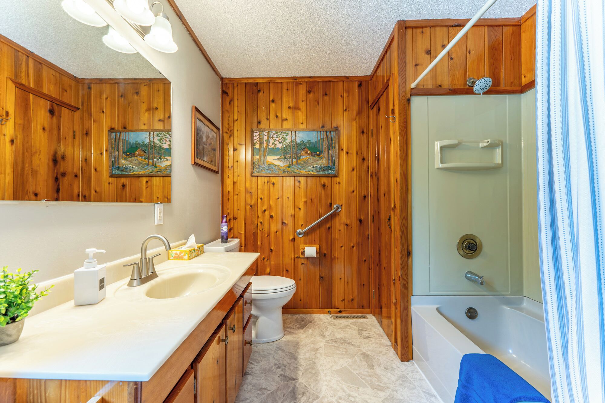 A wooden bathroom with a sink, toilet, and bathtub.