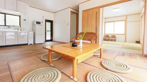 Une pièce de style japonais traditionnel, avec un sol recouvert de tatamis, une basse table en bois et un espace de détente composé de tatamis.