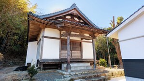 Un bâtiment japonais traditionnel, doté d’une structure en bois et d’un toit recouvert de tuiles.