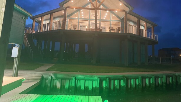 Una casa grande de varios pisos, con un balcón destacado y un espacio al aire libre cubierto.