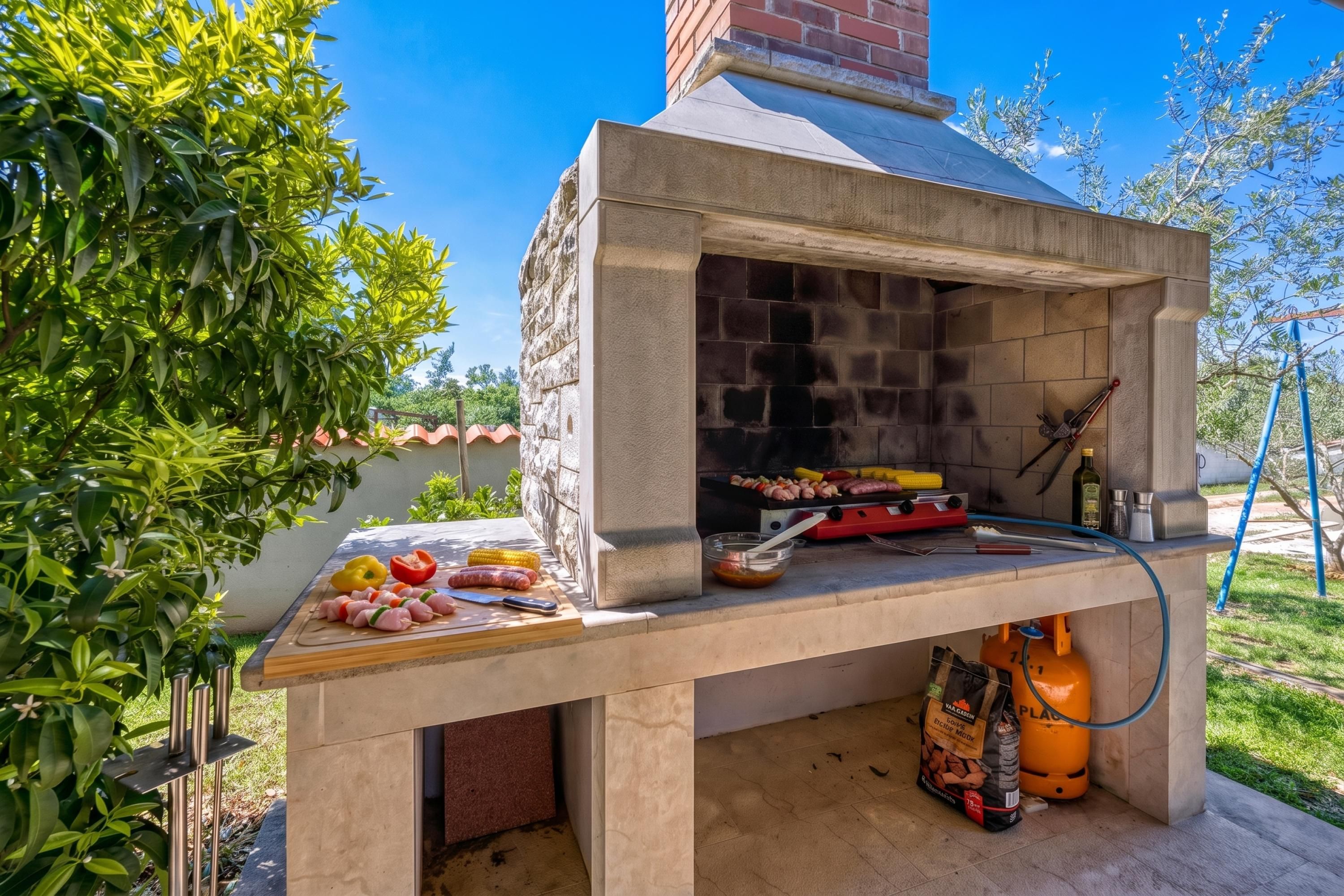 Parrilla de ladrillo exterior con brochetas de carne y verduras, una tabla de cortar y utensilios para asar.