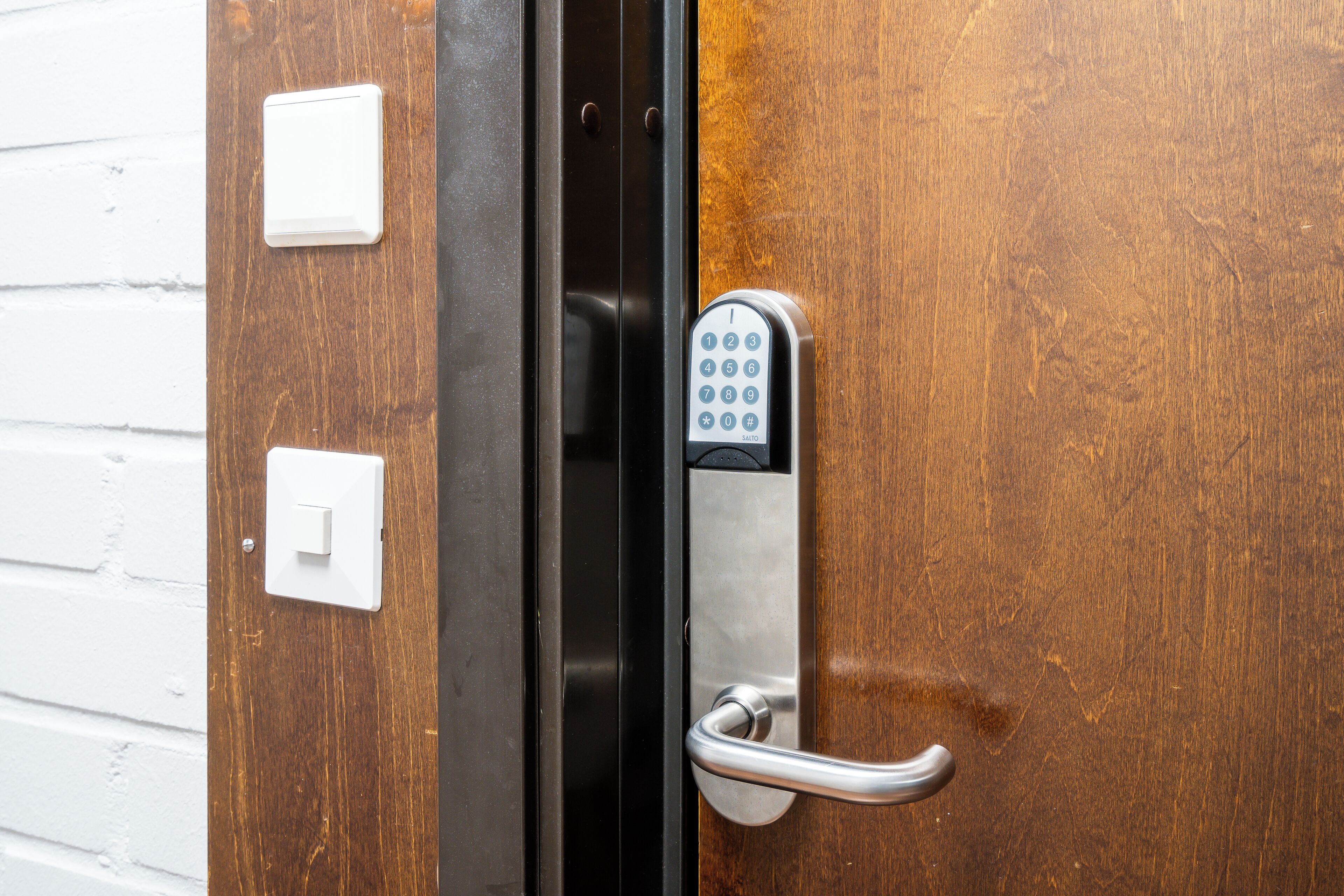 A door with a keypad lock and a handle.