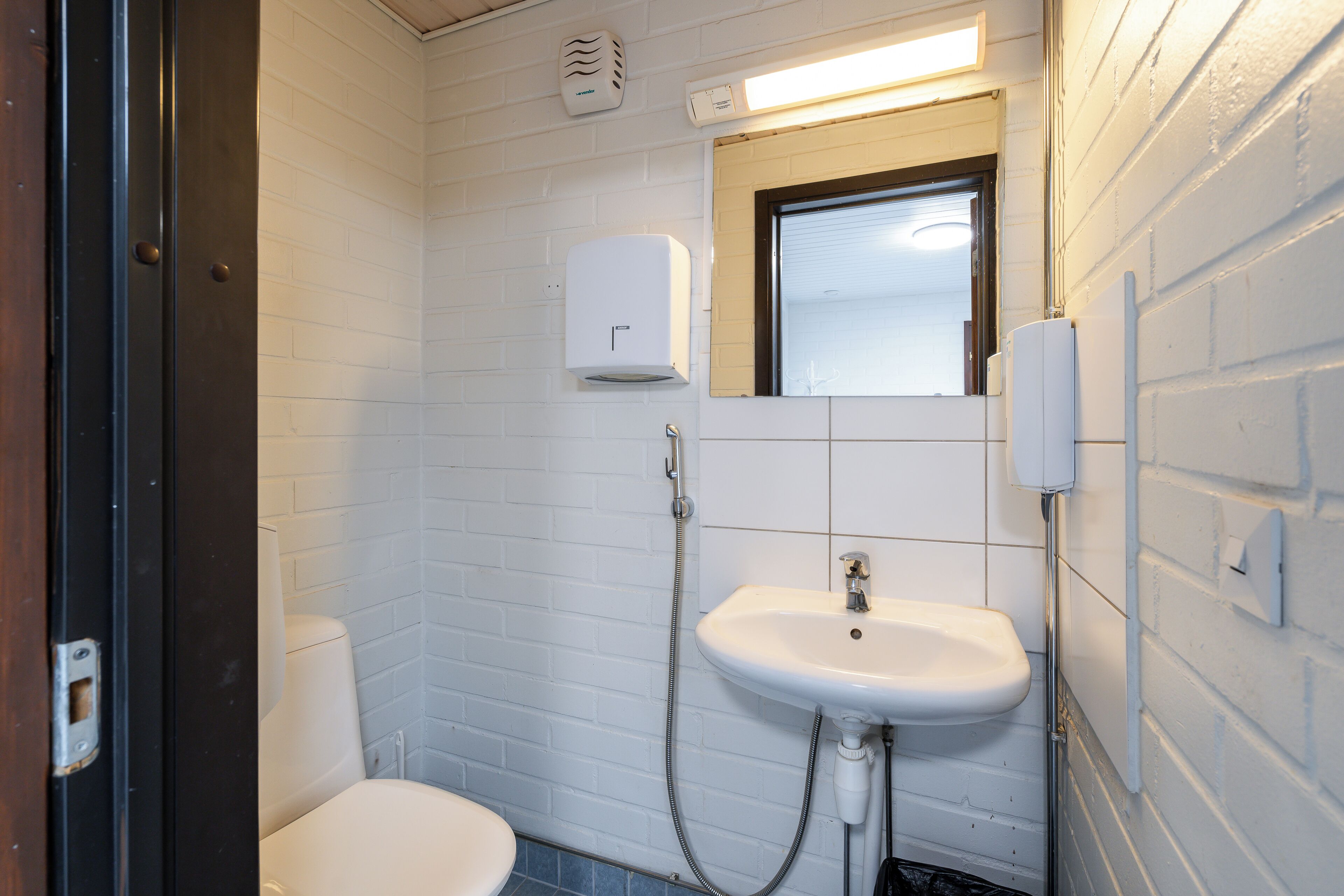 Un baño pequeño y limpio con inodoro, lavabo y espejo.