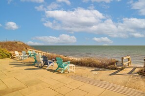 Une zone située au bord de la plage, aménagée avec des chaises et un panneau indiquant qu’il s’agit d’une propriété privée.