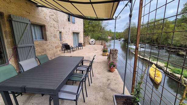 A terrace with a table and chairs, overlooking a river. - LE COTTAGE DE JOUSSEAUME (Mortagne-sur-Sèvre)