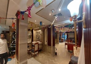 A hotel lobby with a Christmas tree, seating area, and a bar. - emilio hotel (Luxor)
