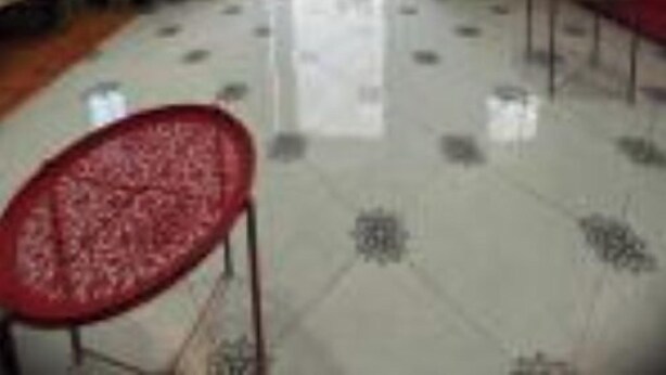 A spacious room with a tiled floor, a red chair, and a doorway leading outside. - At Sondos (Marrakech)