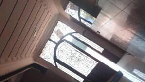 A view of a room with a large window featuring intricate ironwork, a tiled floor, and a patterned wall. - At Sondos (Marrakech)