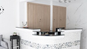 A modern kitchen with a curved island, wooden cabinets, and a patterned backsplash. - Agapaki Studios (Neos Marmaras)