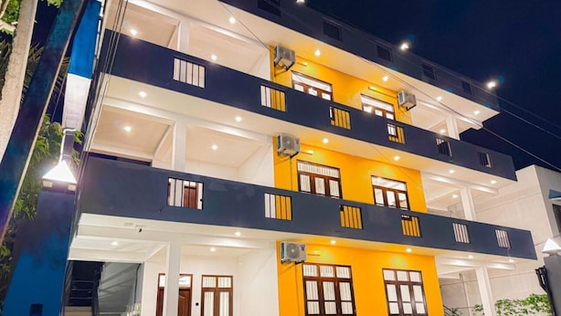 Un edificio de varios pisos con balcones, ventanas amplias y una entrada bien iluminada.
