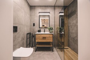 A modern bathroom with a wooden vanity, a mirror, and a glass shower enclosure. - Grande Komfort i Przestrze Widok na Las Shellter Rogowo (Trzebiatow)