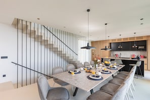 Enjoy meals with family and friends in this spacious dining area, featuring a long table and six comfortable chairs.