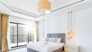 Een moderne hotelkamer met een groot bed, een nachtkastje en uitzicht op de stad door het raam.