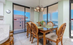 Enjoy meals in this dining area with a table and chairs, offering a view through the glass door to the outdoors.