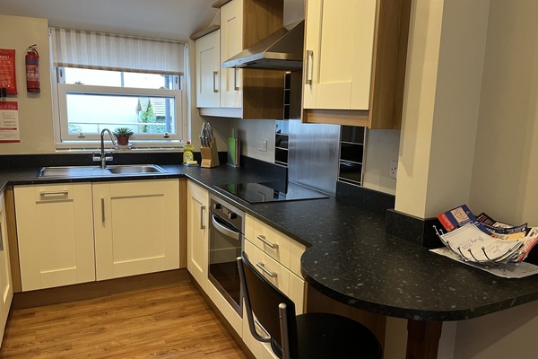 Kitchen with appliances and compact breakfast bar