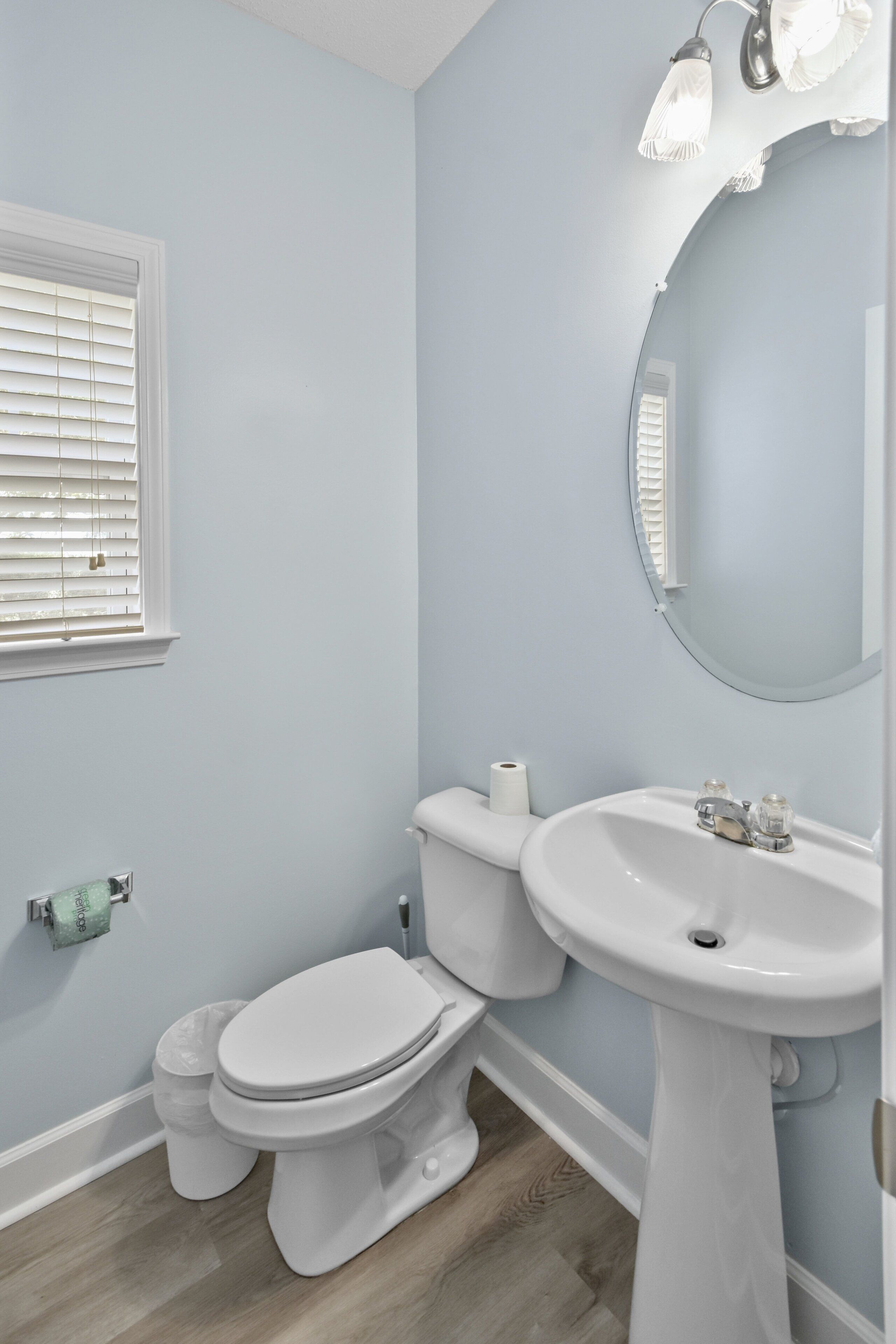 A bathroom with a toilet, sink, and mirror.