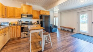 A modern kitchen with wooden cabinets, stainless steel appliances, and a large island.